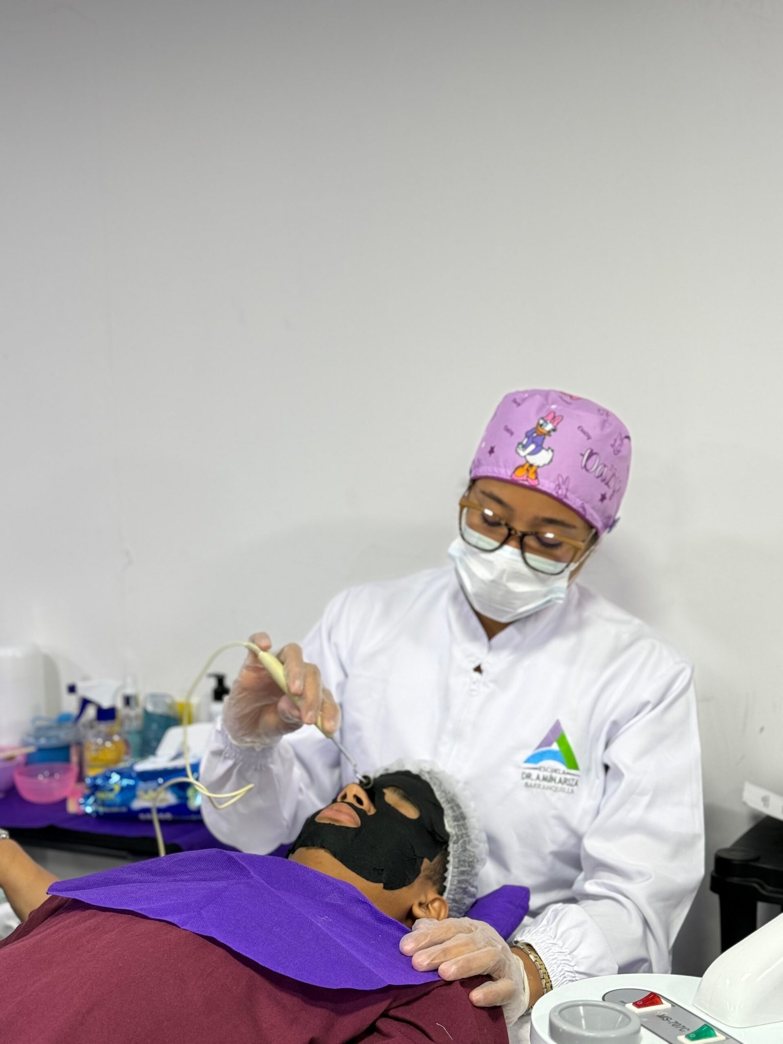 Estudiante de cosmetología realizando una práctica facial supervisada